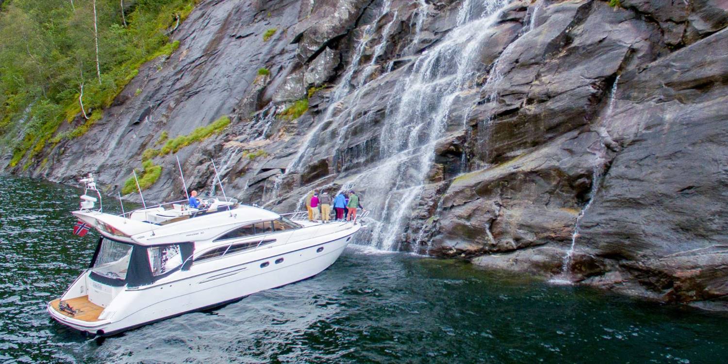 Luxury stay in Bergen - one of a kind activities and attractions - private fjord cruise to Modalen - boat next to a waterfall
