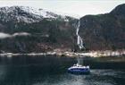 Steep mountains, fjord and waterfall