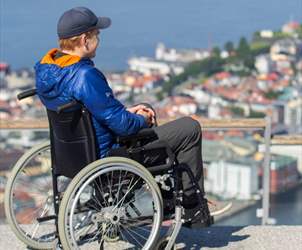 Handicap friendly attractions and museums in Bergen - boy in wheelchair enjoys the view of Bergen from Mount Floyen